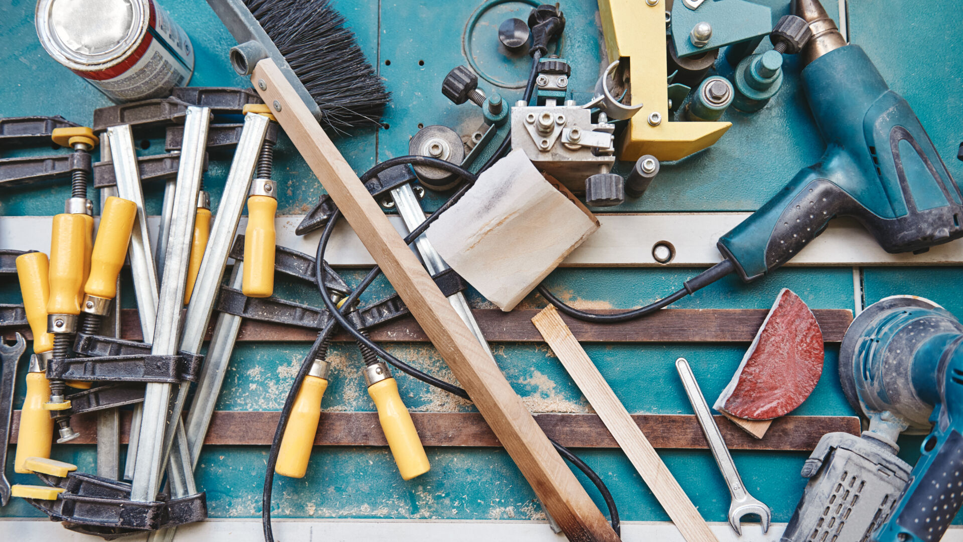 Close up of assorted tools for carpenter lying on the blue working surface. Horizontal shot